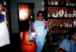 Reham, the youngest student receiving her ribbon and guitar.